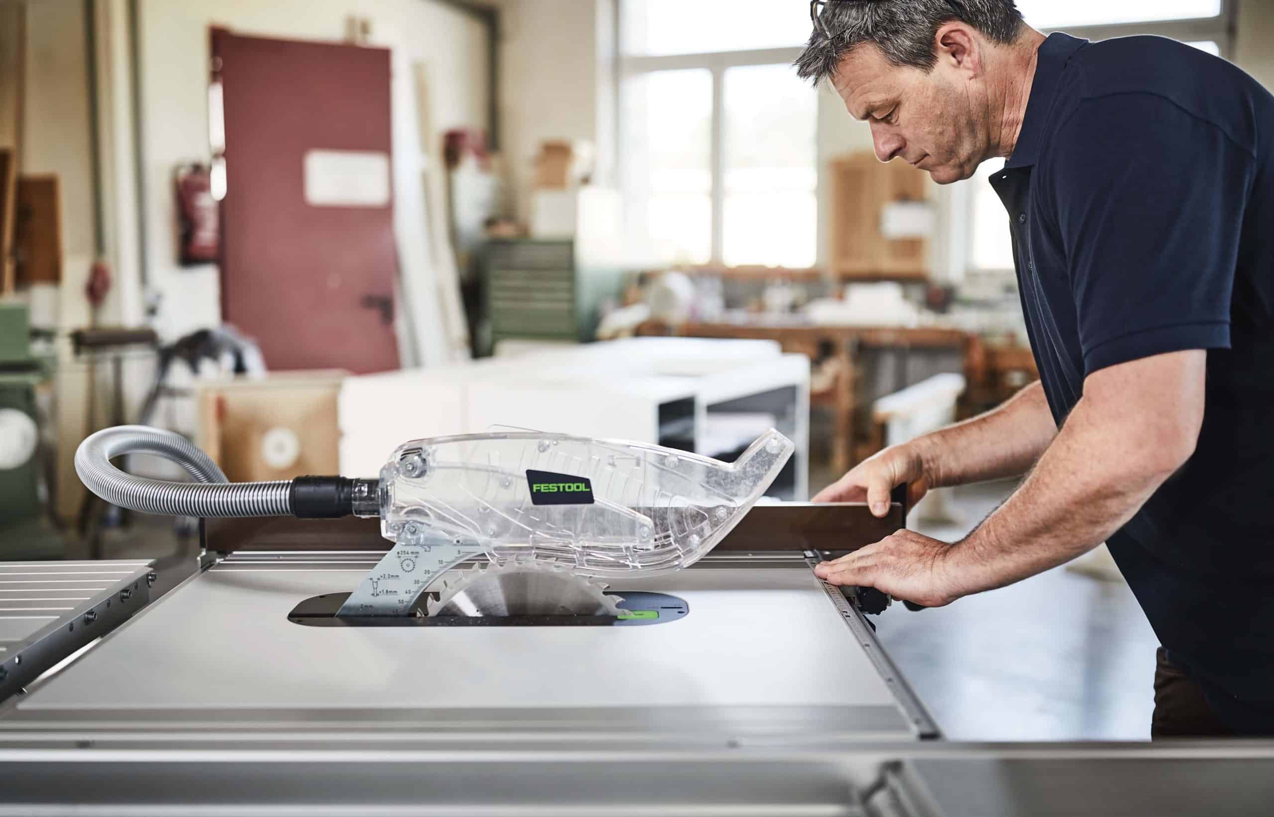 Professional tradesman adjusting the fence on a Festool TKS 80 EBS table saw
